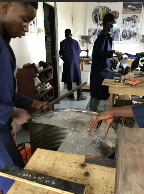 Learners practising metalwork in a WOCOET workshop